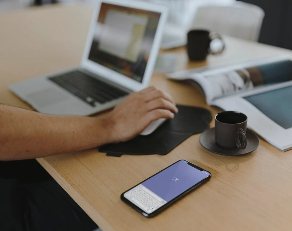 Mężczyzna przegląda responsywną stronę na laptopie i smartfonie Mężczyzna przegląda responsywną stronę na laptopie i smartfonie