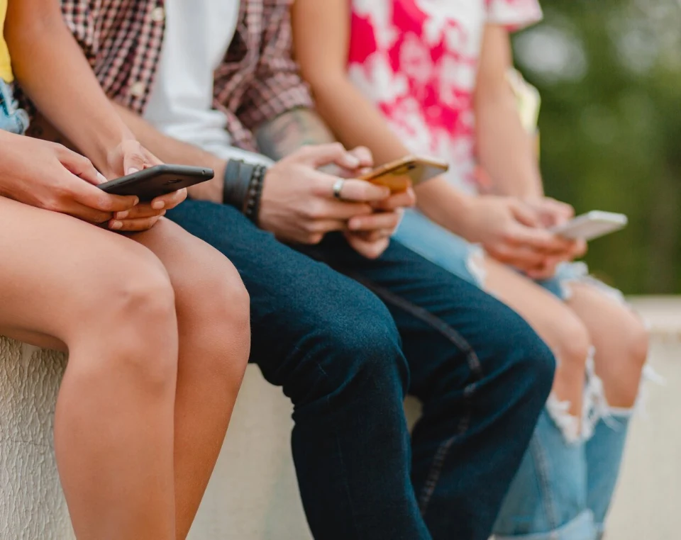 Młodzi ludzie przeglądają media społecznościowe na smartfonach